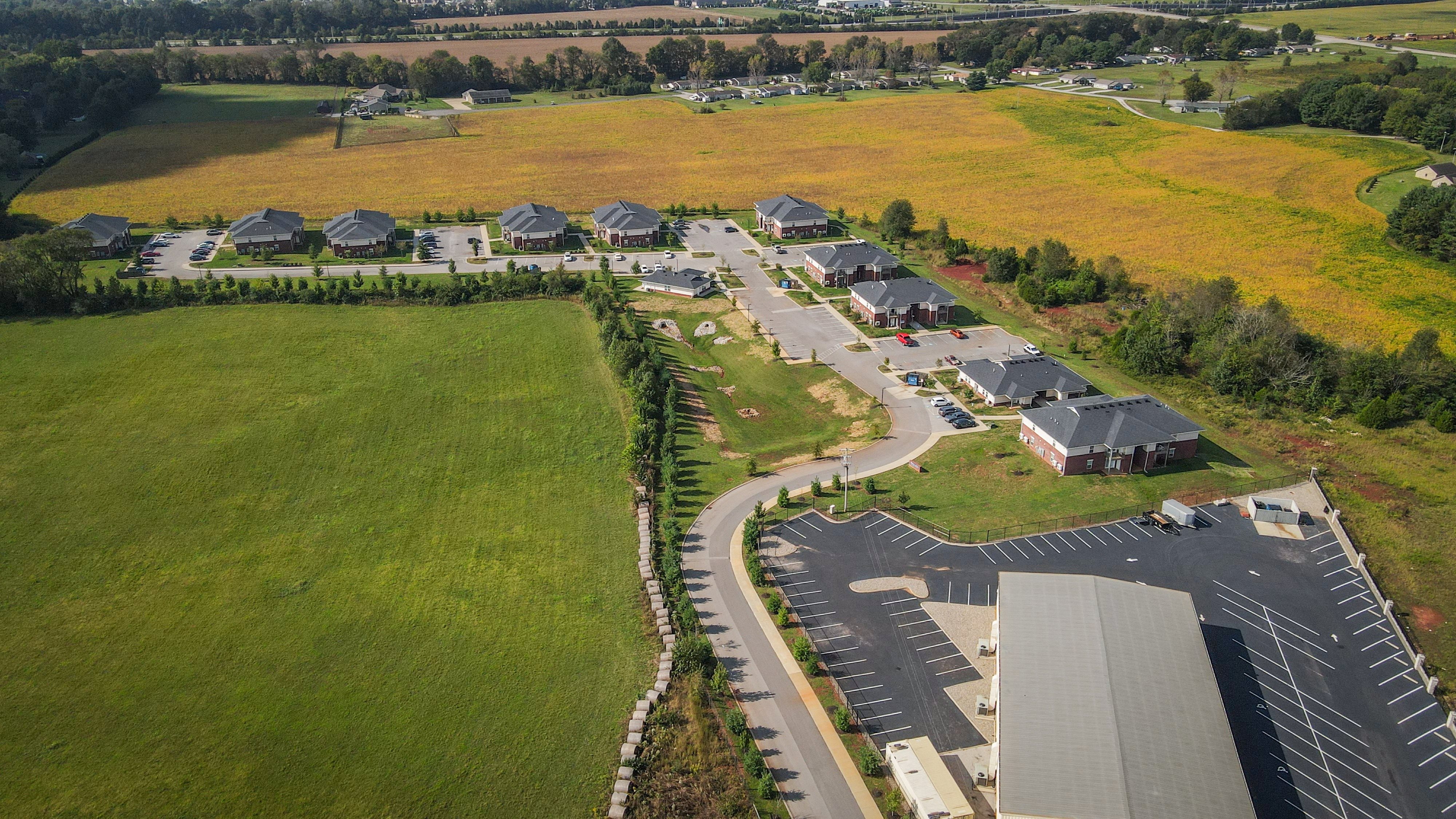 an aerial view of a neighborhood of houses on a road and a field